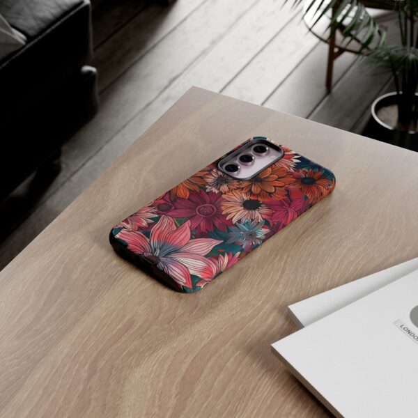 a phone with a Maximalist Floral Pattern Phone Tough Case on a wooden desk.